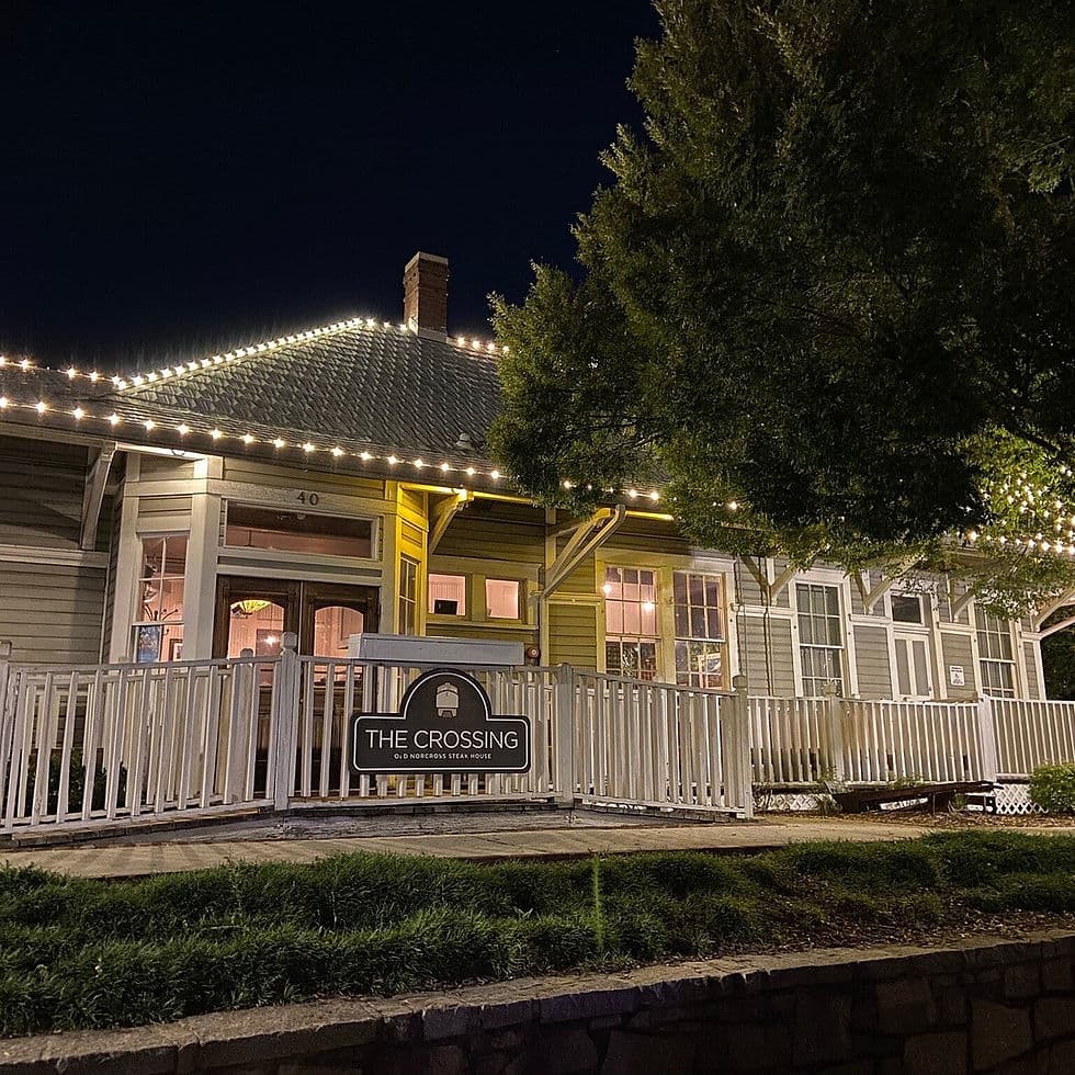 The lit porch and sign of Rathburn Steakhouse in a restored house at 40 Depot Street